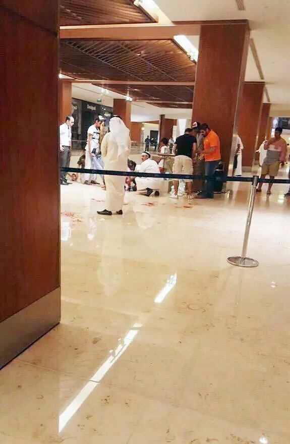 رواد المجمع يحيطون بالقتيل محاولين إنقاذه