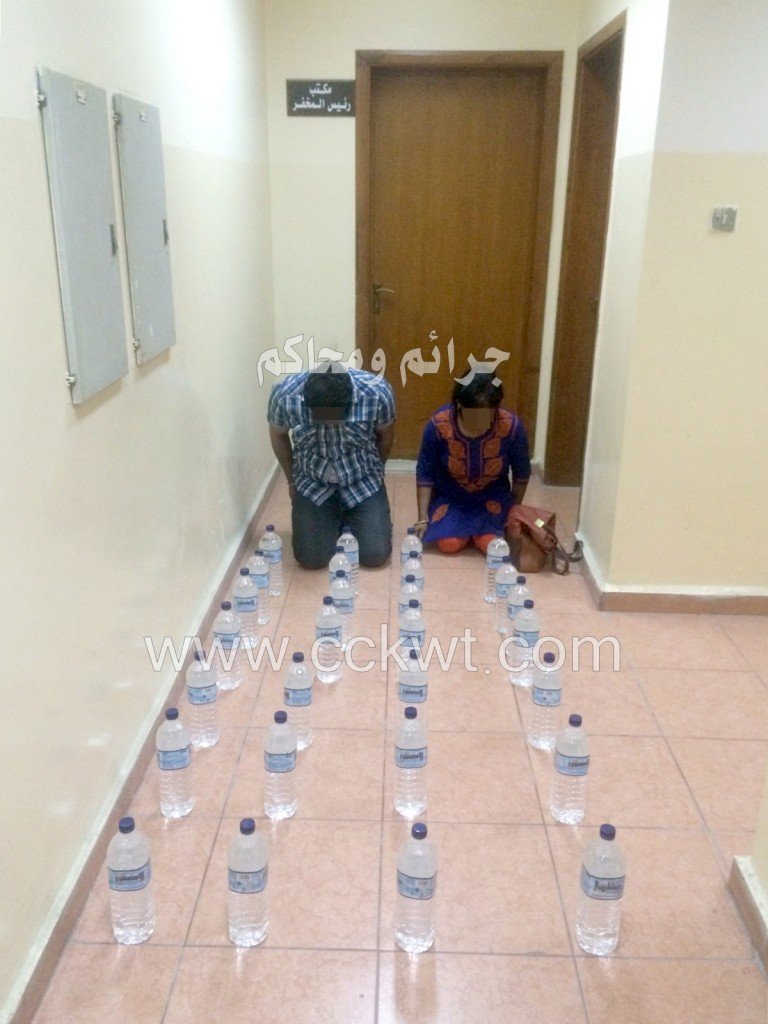 المتهمان أمام خمورهما المحلية