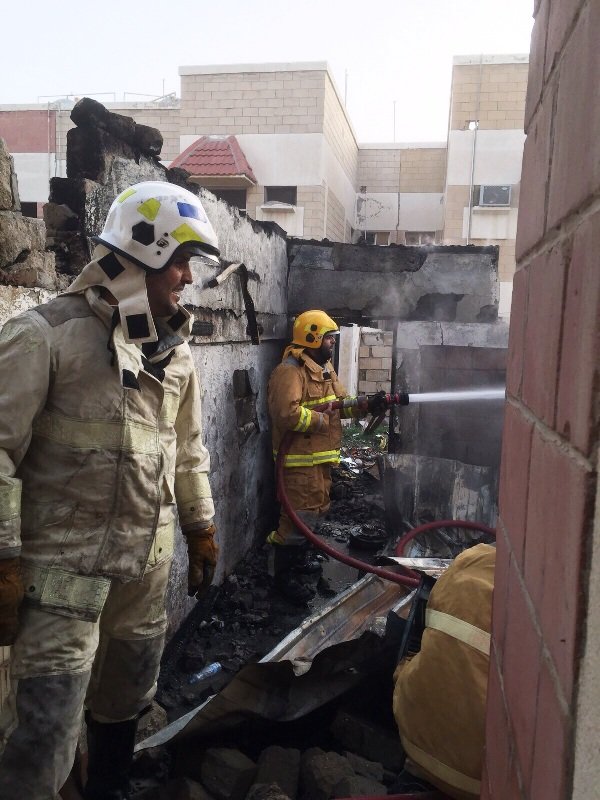رجال الإطفاء خلال إخمادهم حريق المنزل